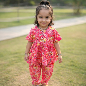 Girl standing in Basic Tribe Jhilmil pink printed cotton co-ord set with matching pants