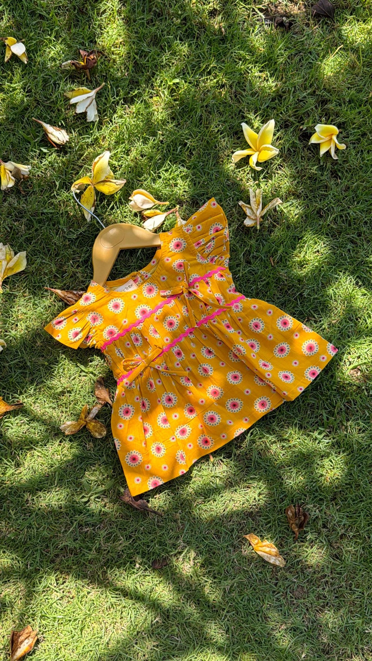 Flat lay of Basic Tribe Pretty Wow yellow floral top showing silhouette and ruffle sleeves