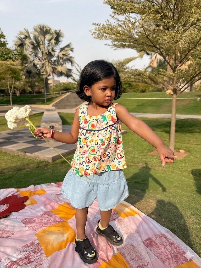 Girl playing outdoors in Basic Tribe Masakkali multicolour printed cotton top