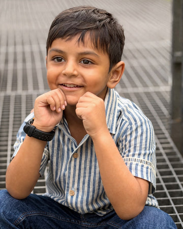 Boy wearing Basic Tribe Neer blue-and-white striped cotton shirt in outdoor close-up