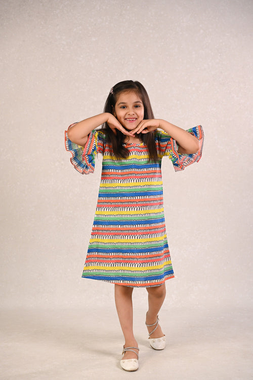 Girl wearing Basic Tribe Carnival rainbow-striped cotton dress with flared sleeves