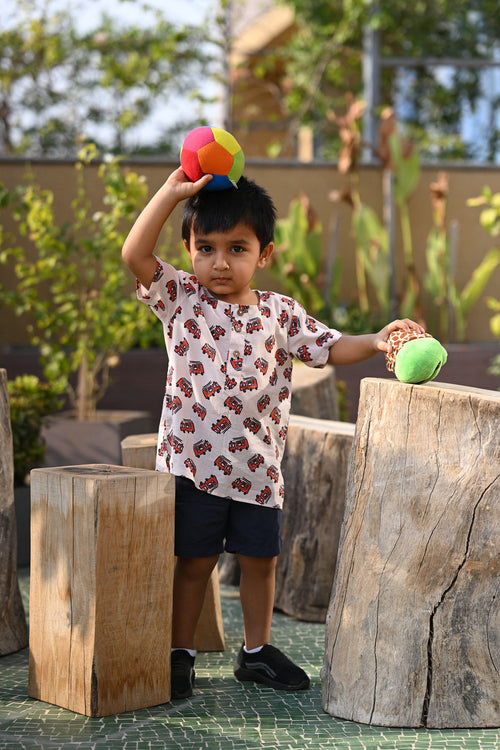 Boy wearing Basic Tribe Firebuddy white firetruck-print cotton shirt with short sleeves